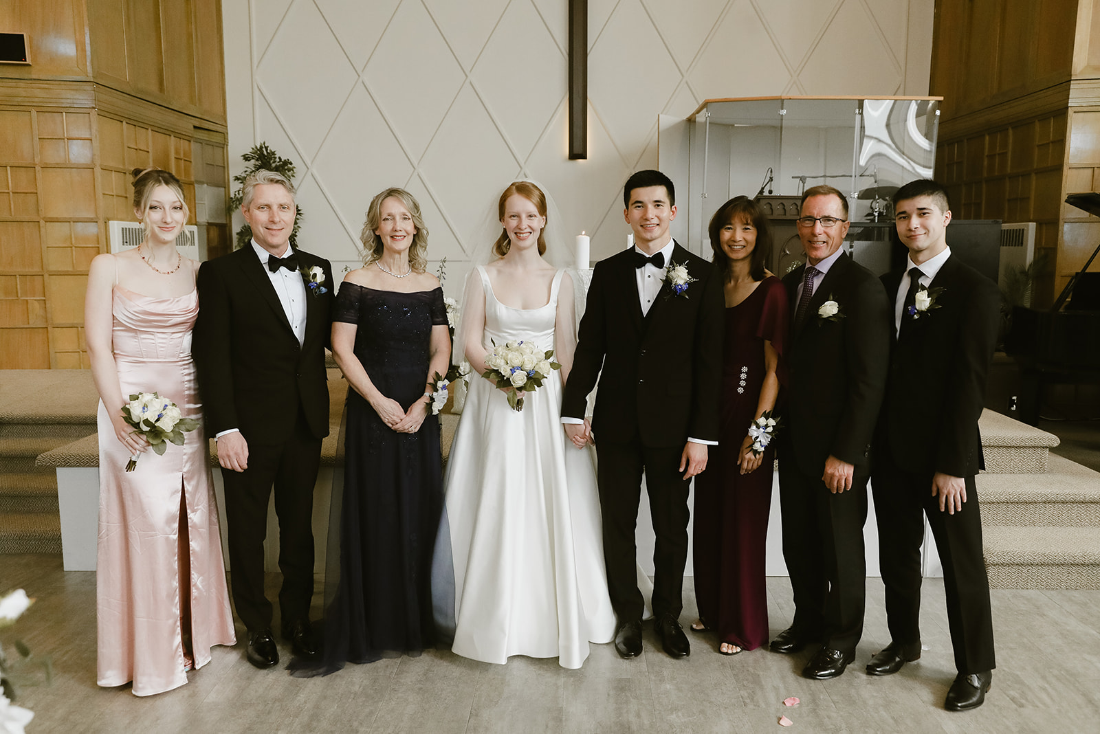 Bride and Groom with families, smiling at the camera.