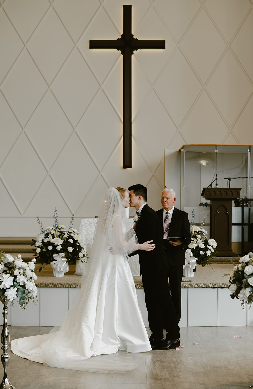 Bride and Groom kiss at the alter