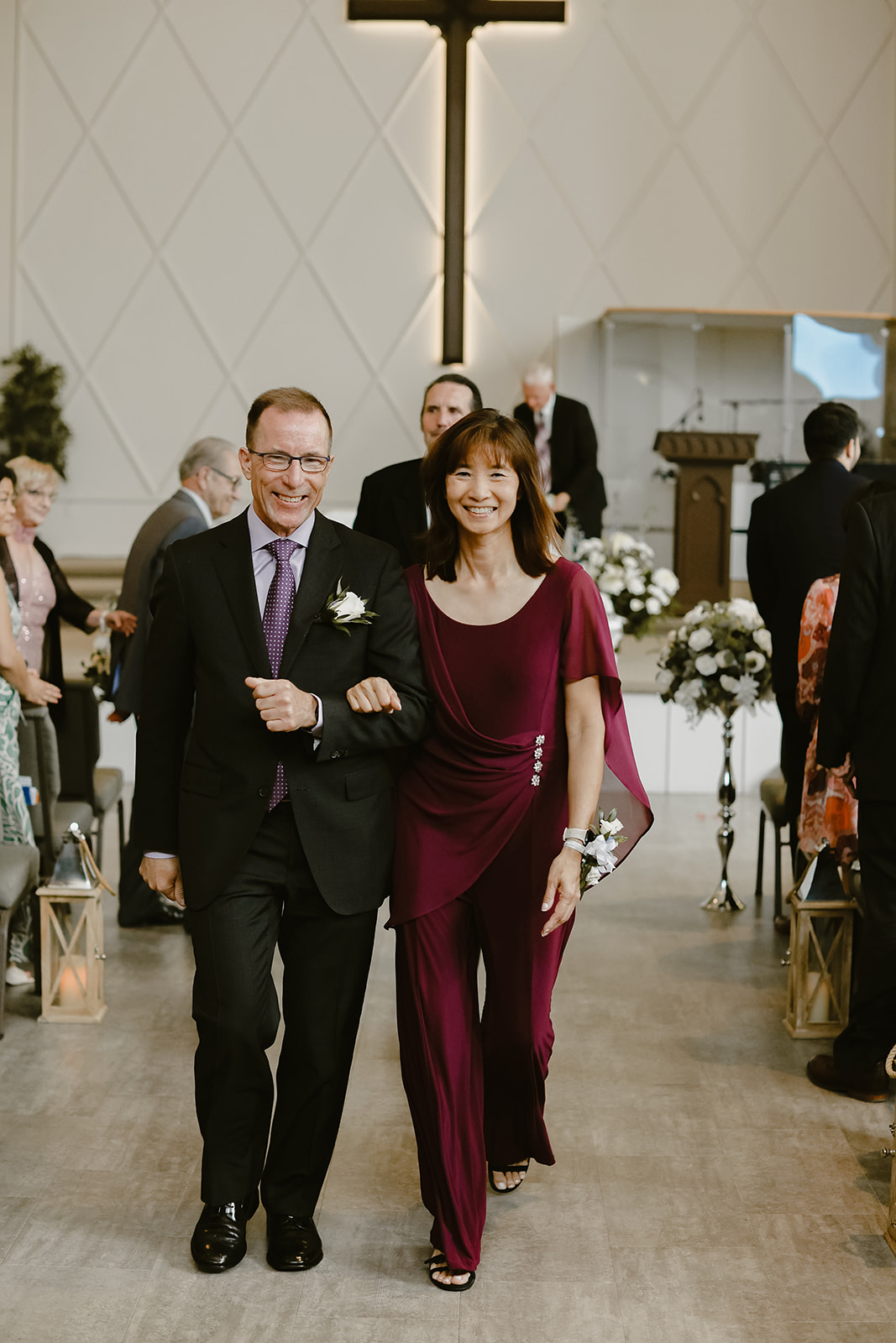 Grooms parents walk down the isle. 