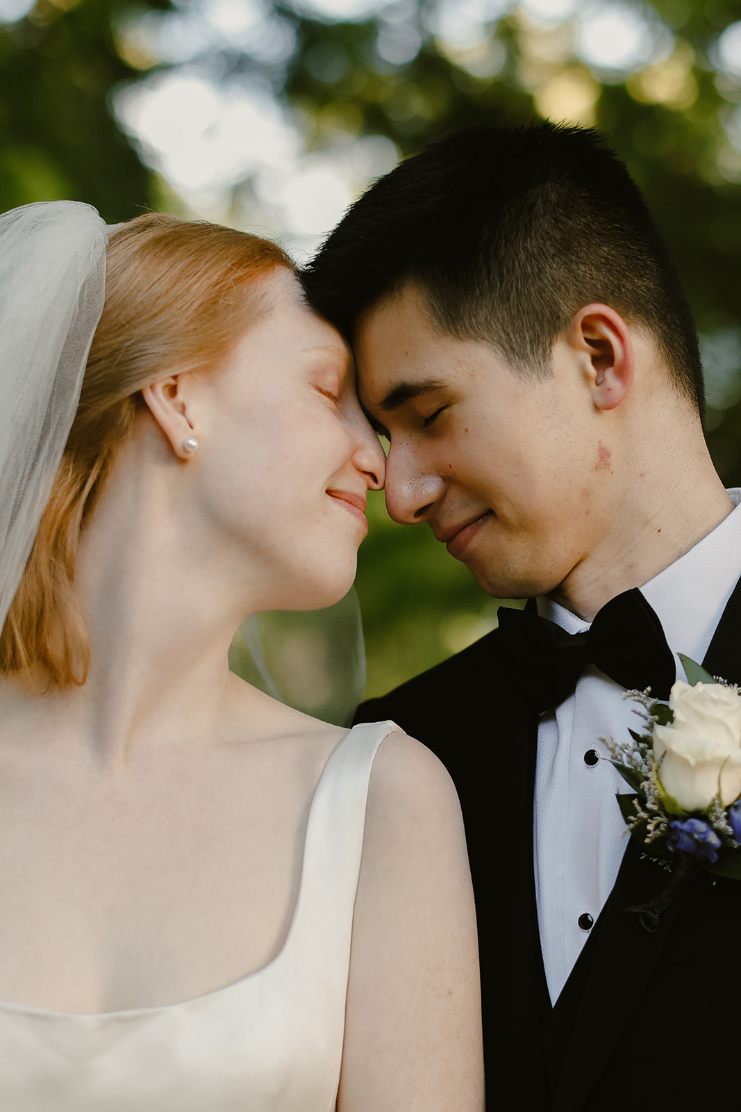 Bride and Groom in close embrace with foreheads touching.