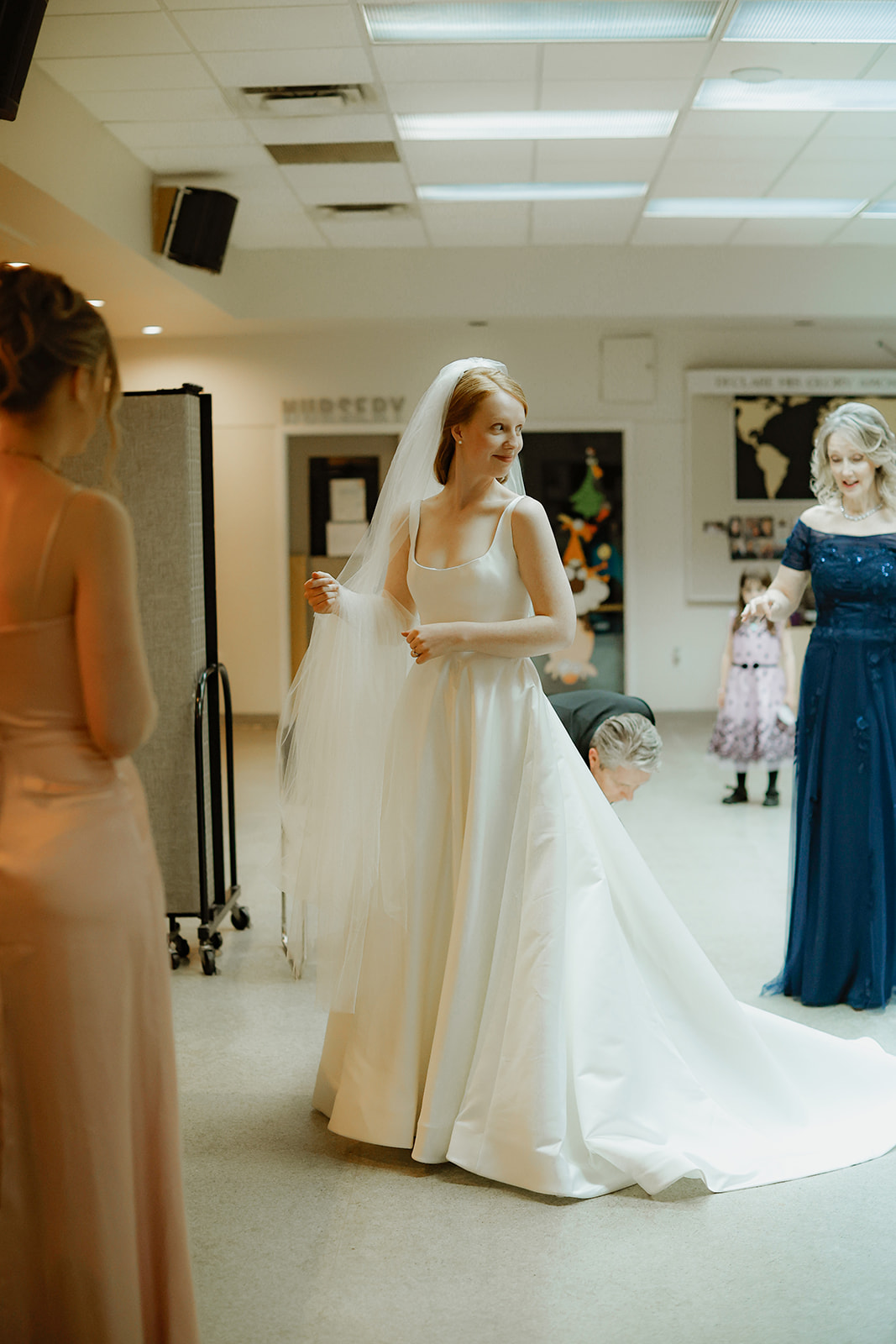 Bride getting ready for her wedding ceremony. Family is gathered around her. 