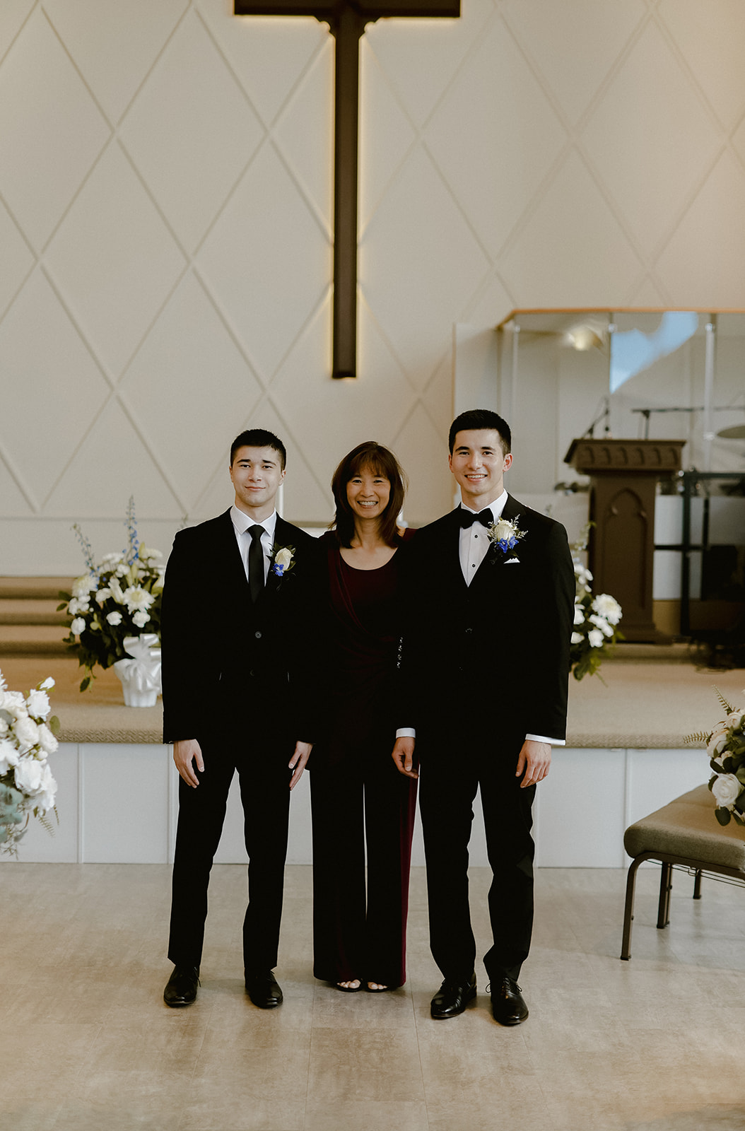 Groom smiling at camera with brother and mother