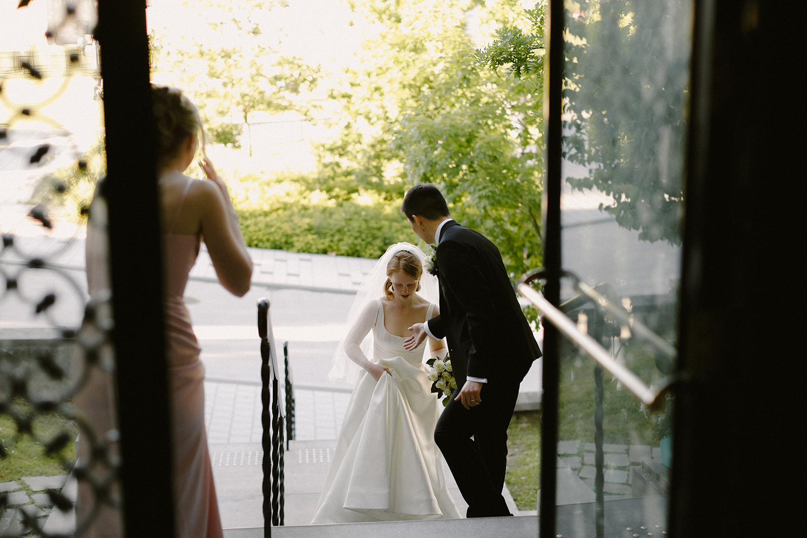 Bride and groom walk up steps to reception