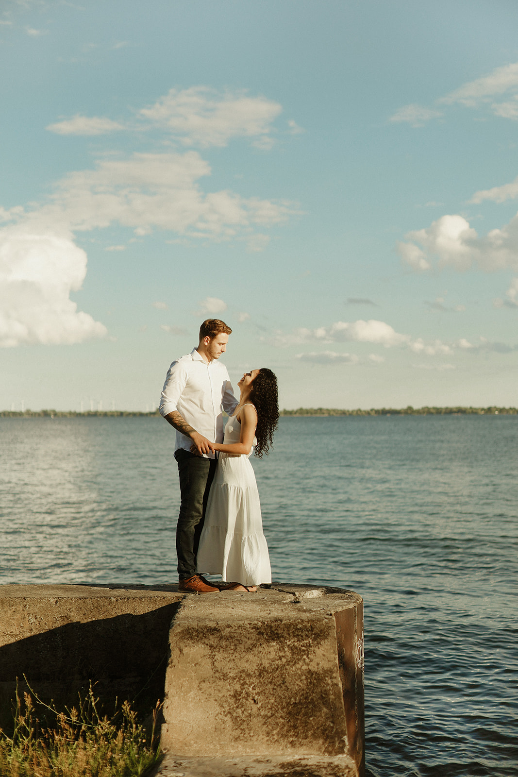 Man and woman hold each other by lake Ontario. Kingston Ontario Photography. 