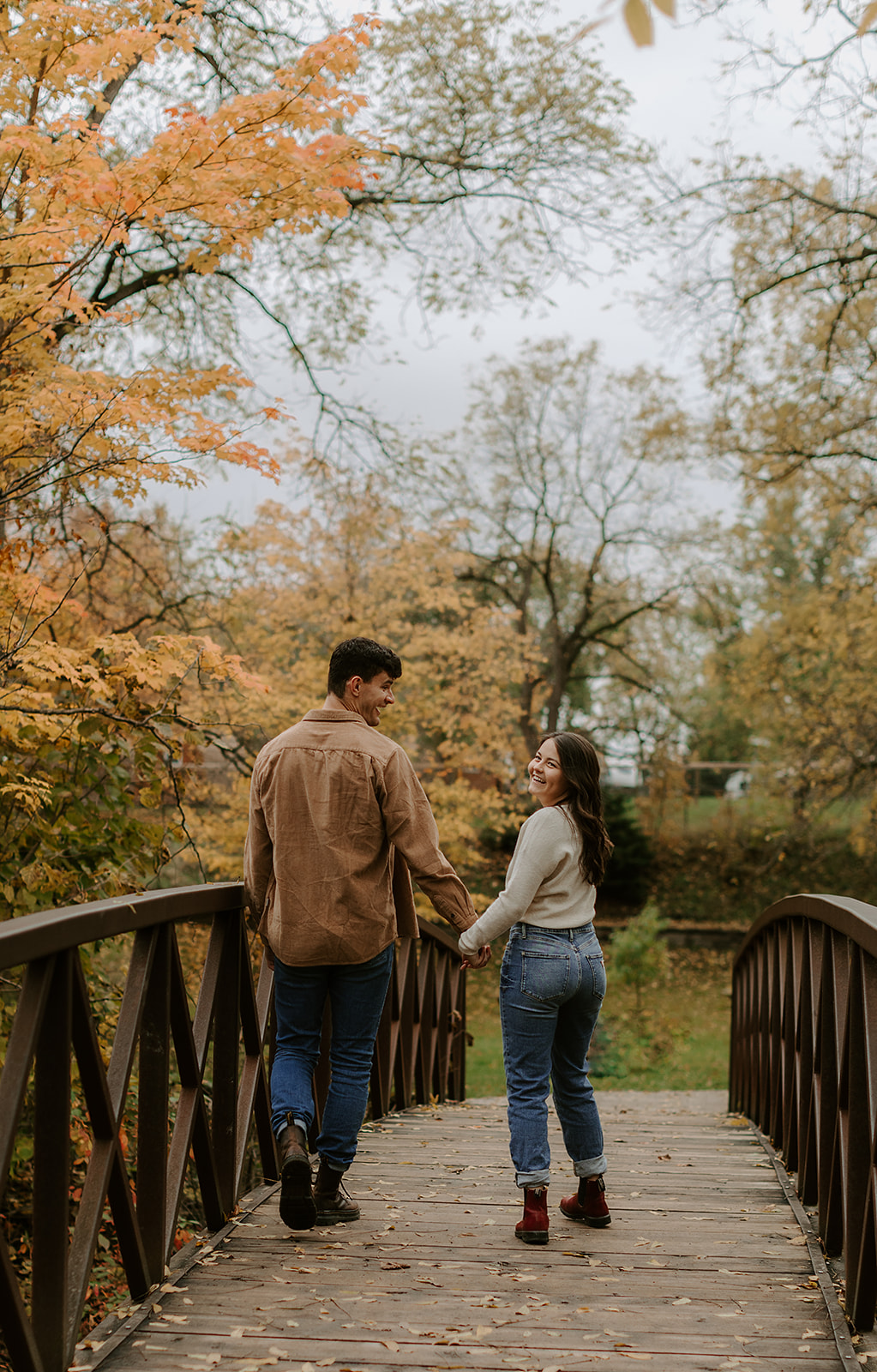 Engagement Photoshoot in Kingston, ON. Couple walking on bridge.