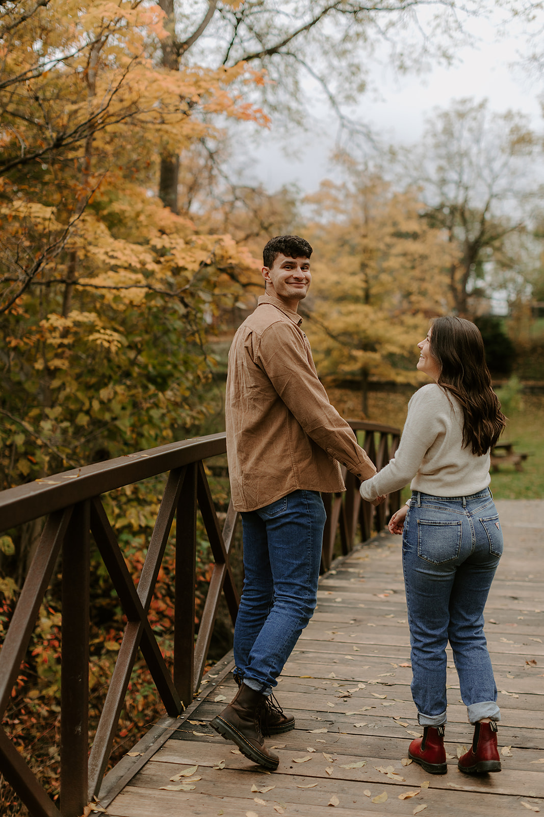 Engagement Photoshoot in Kingston, ON. Couple walking on bridge.