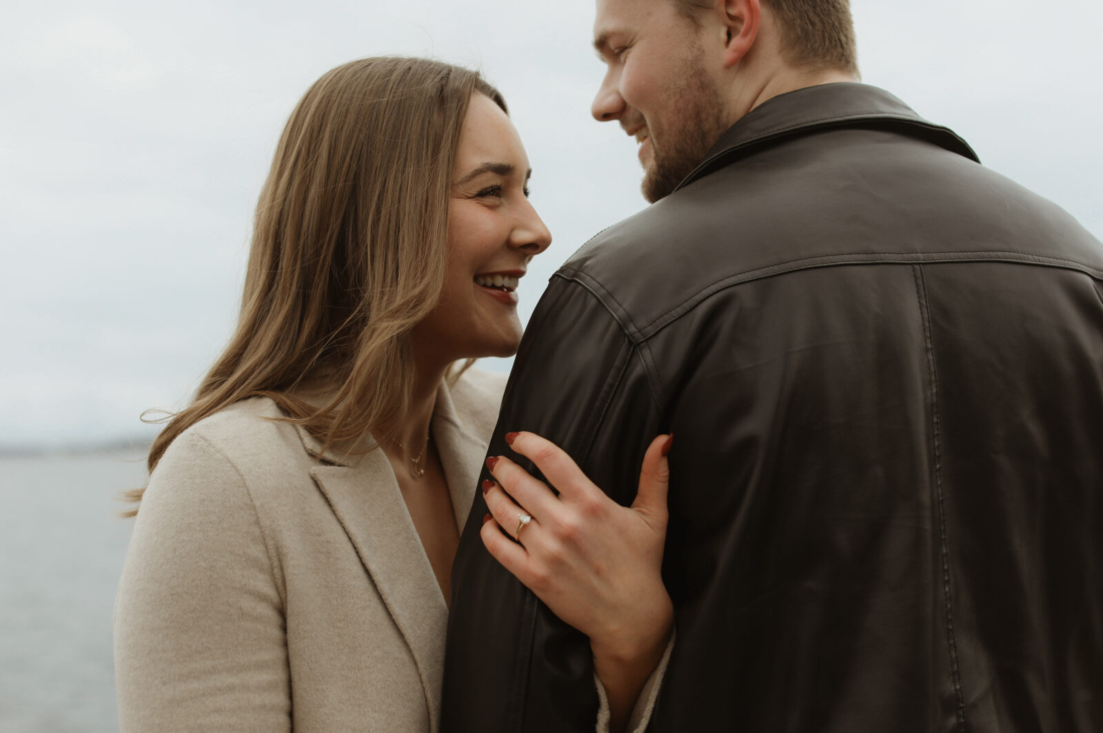 couple laughing. Women holds mans arms and engagement ring can be seen. Kingston Ontario photography