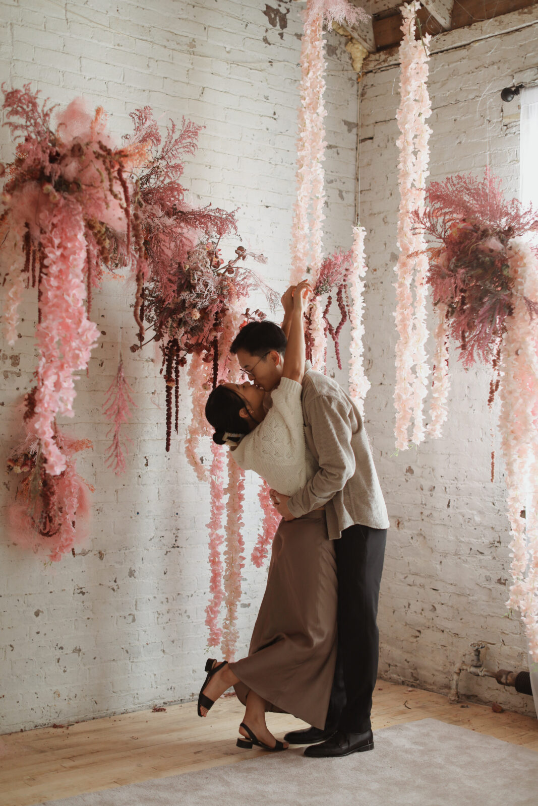 Couple kissing. Background white brink with pink flowers