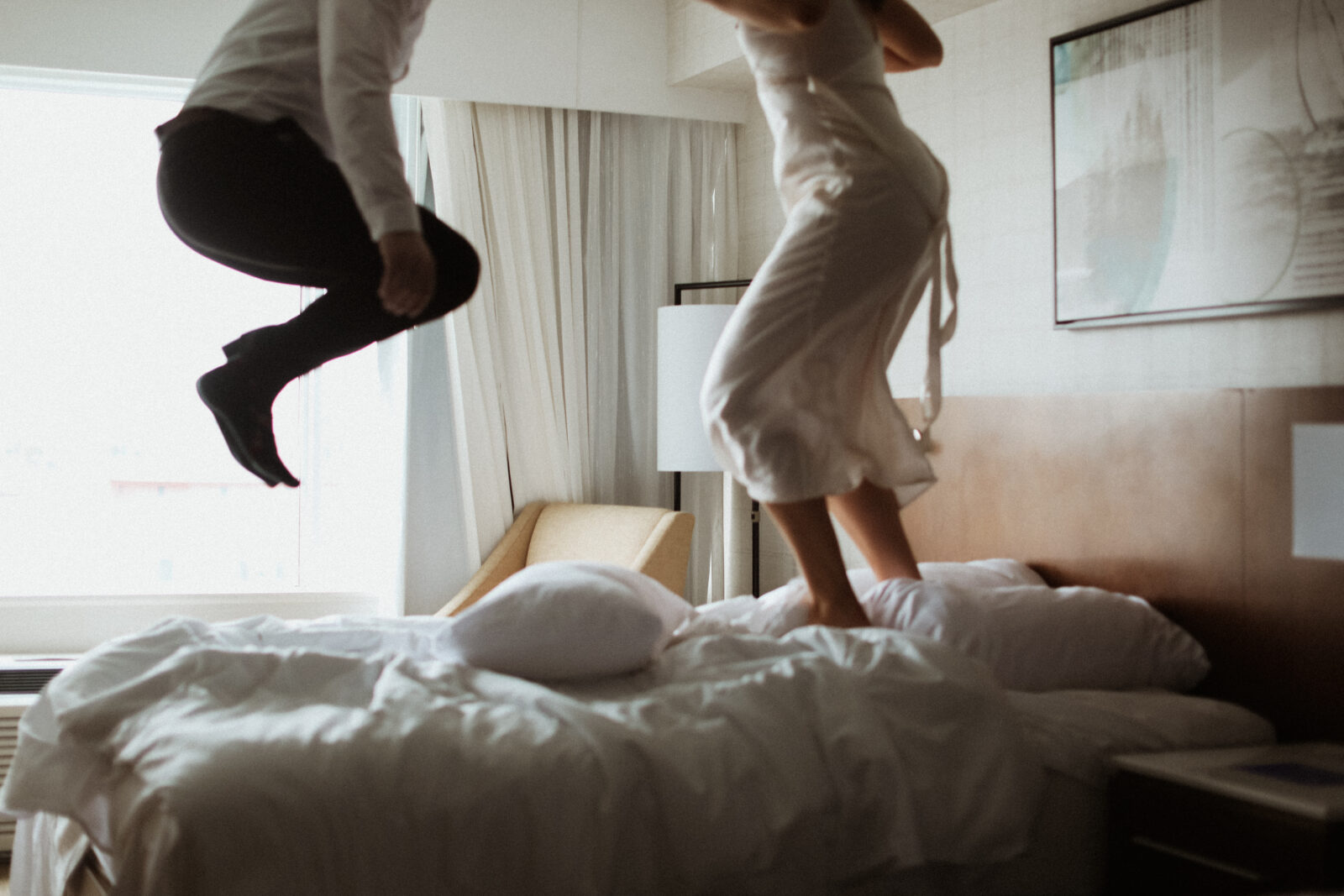 couple jumps on bed