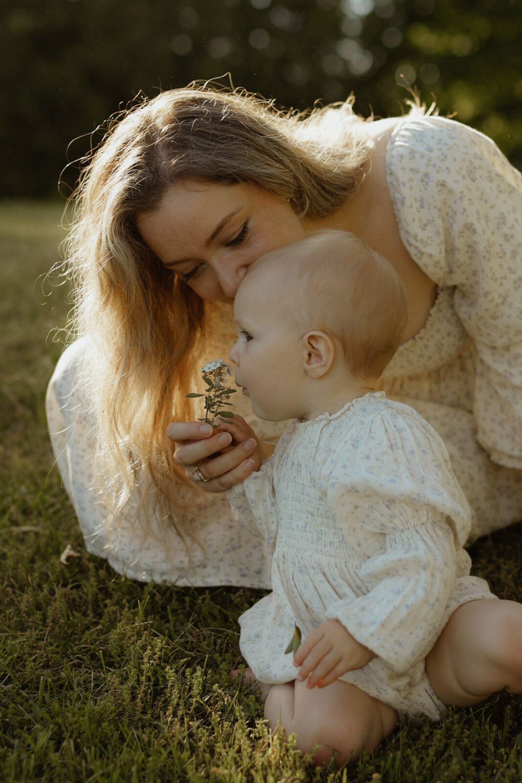 Mom holds flower to daughters nose to smell - Family photo shoot - Lake Ontario Park, Kingston Ontario