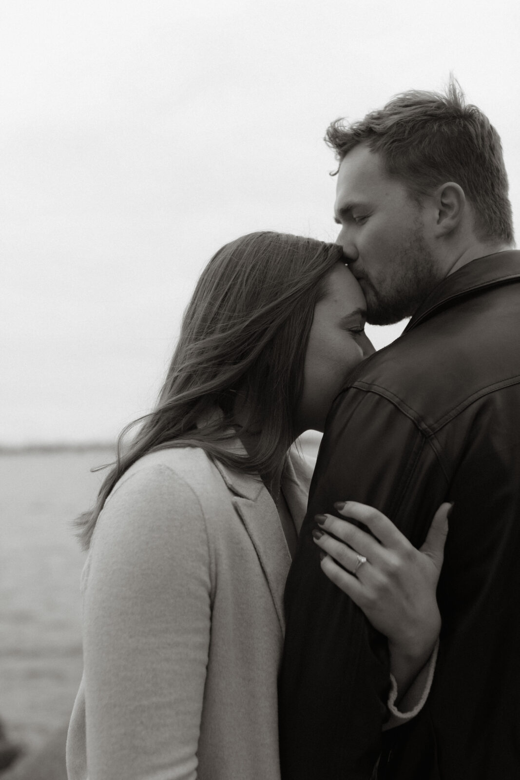 Couple next to lake Ontario- Kingston Ontario Engagement photo shoot 