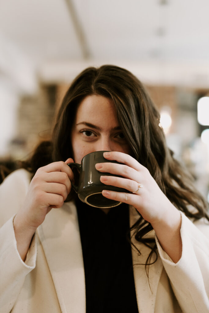 woman sips a cup of coffee in kingston ontario