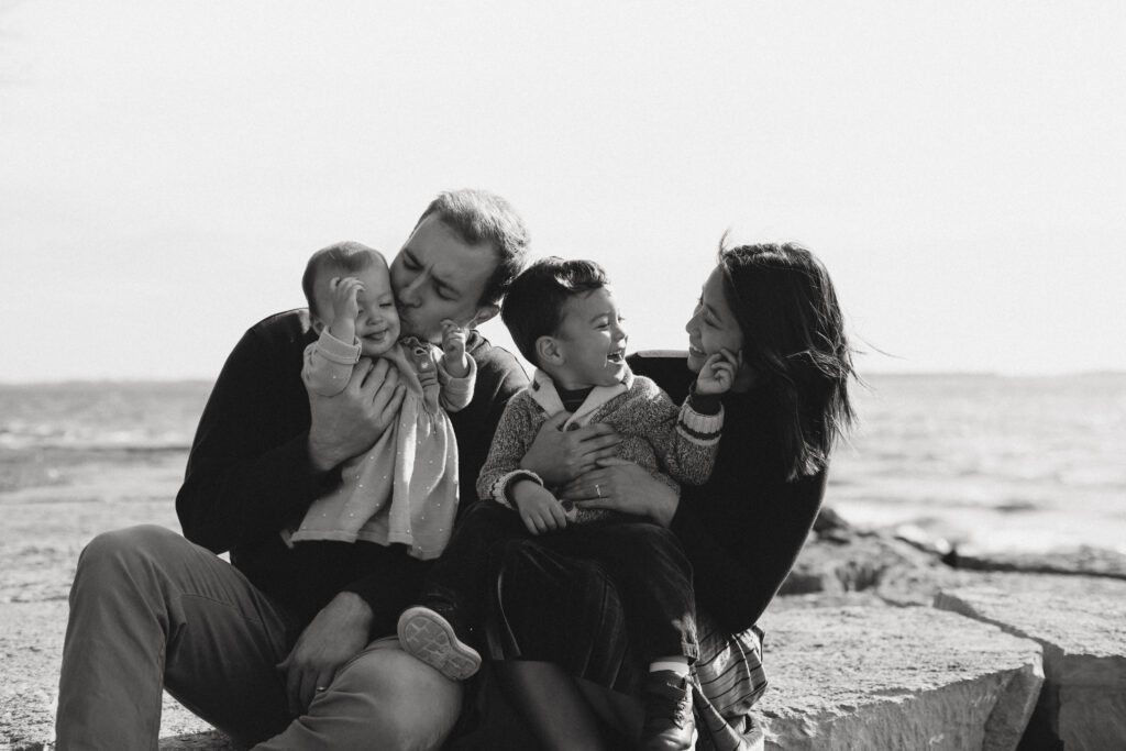 Black and white images of family sitting on rocks in Kingston Ontario