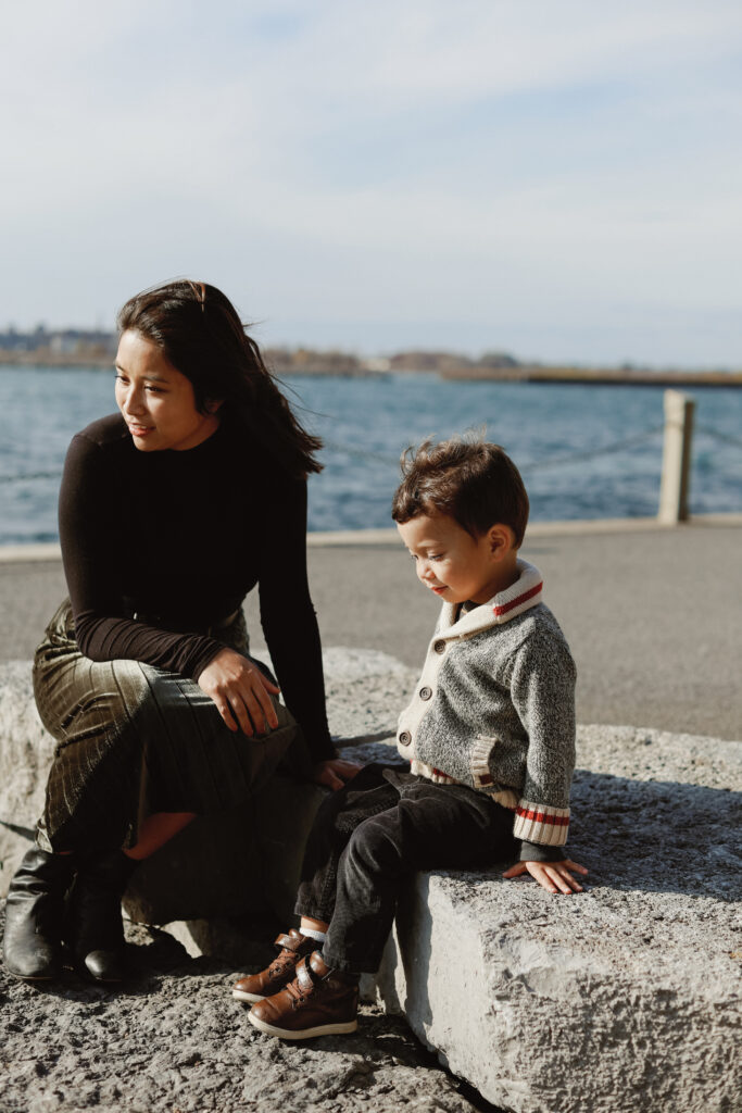Mom and son sit on rocks 