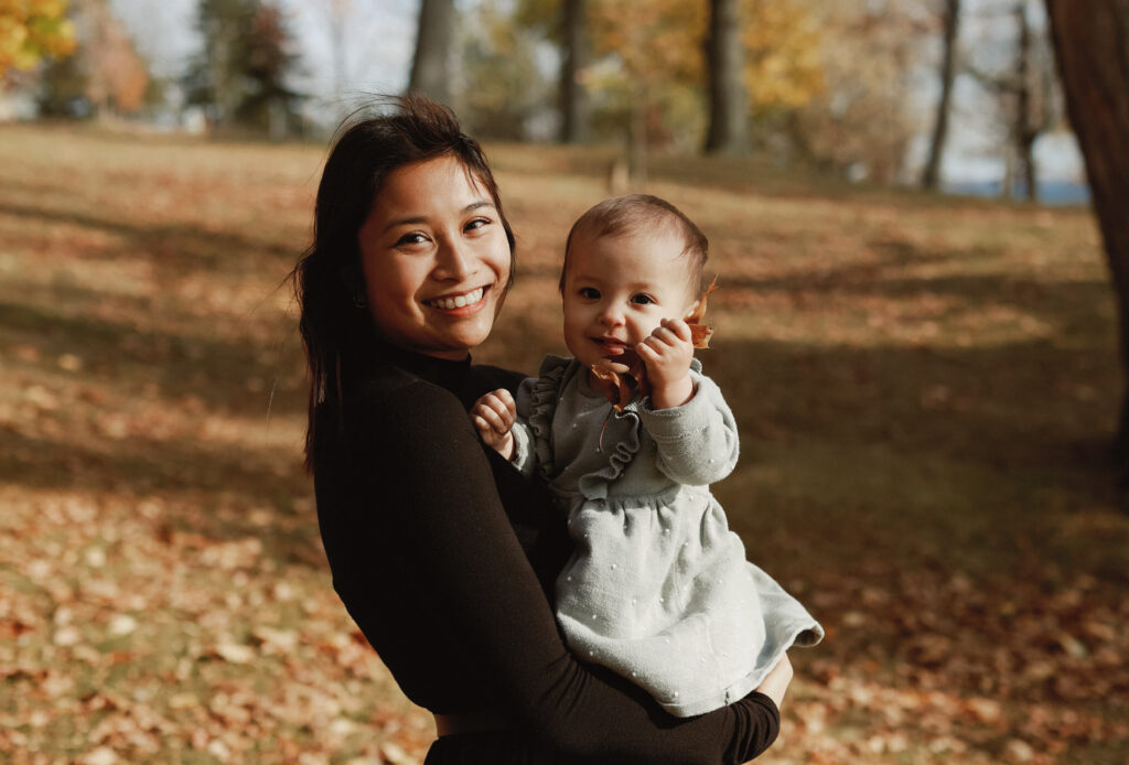 Mother holds baby outside. 