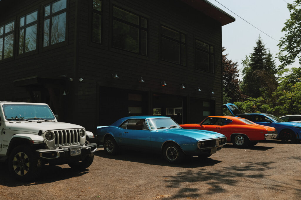 Old fashioned cars parked beside a house