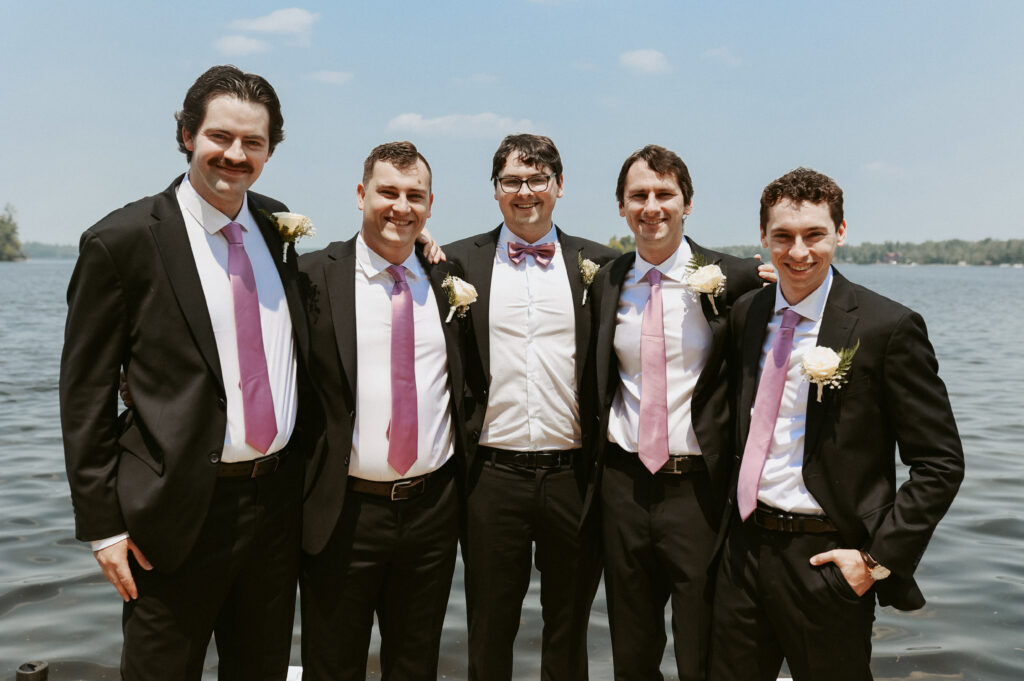 Groomsmen stand together with arms around each other