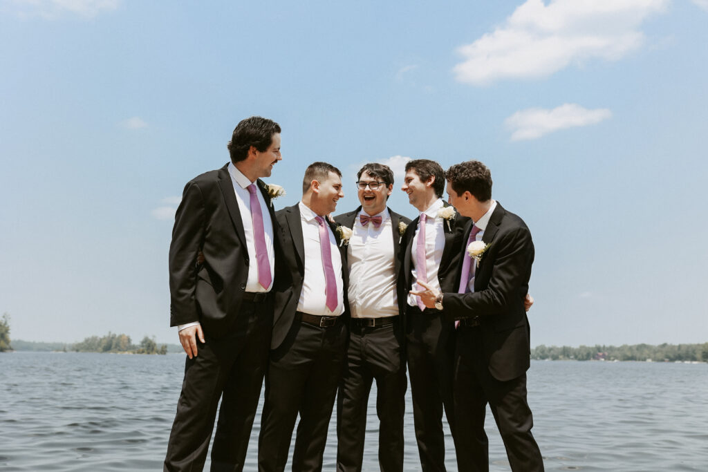 Groomsmen stand together with arms around each other