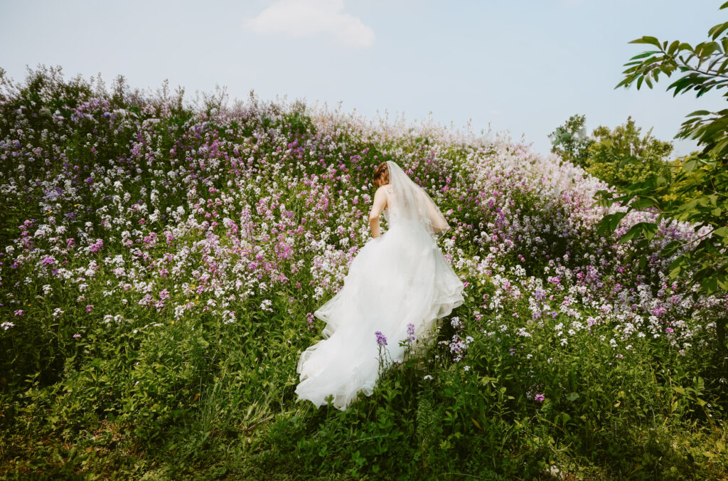 Bride walks in a field of wildflowers