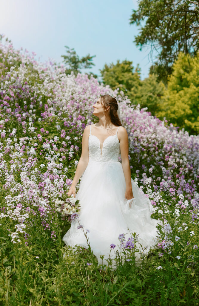Bride stands in a field of wildflowers