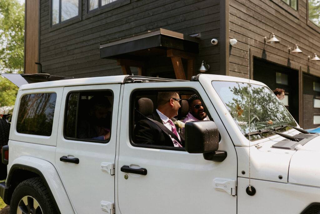 Groomsmen drive away in white Jeep