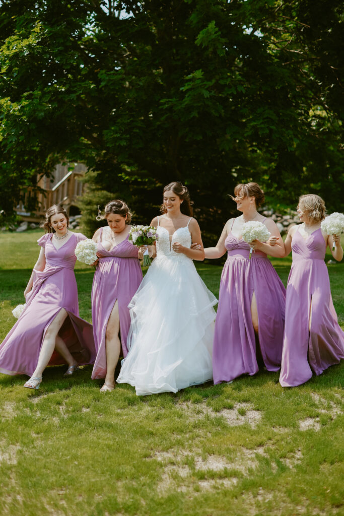 bride and bridesmaids walk with arms linked