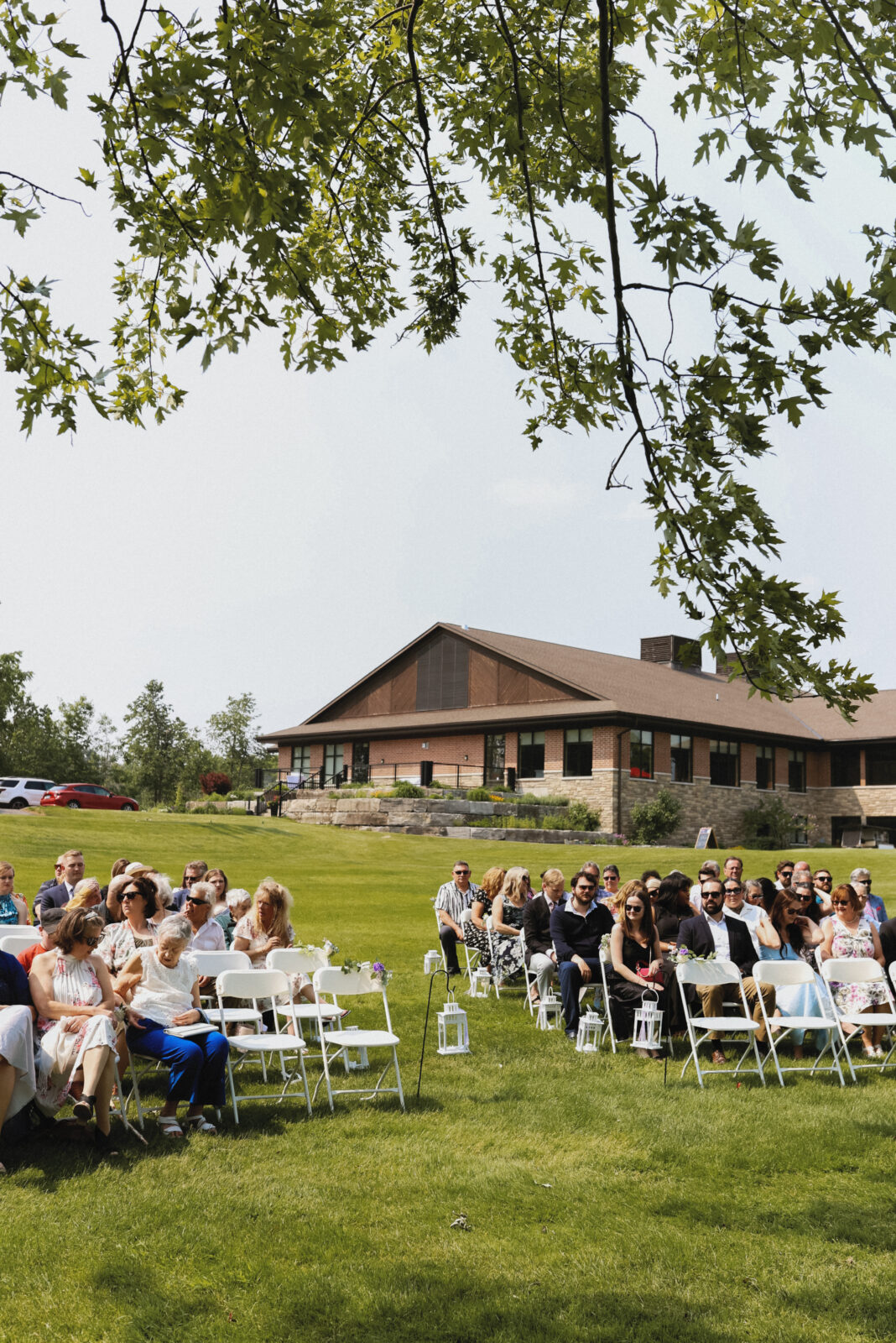 Golf course wedding. Club house featured in the background with isle and guest seated in the forefront.