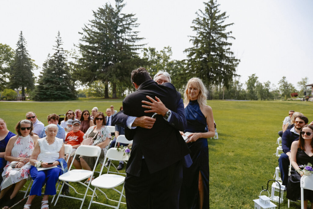 Groom hugs father