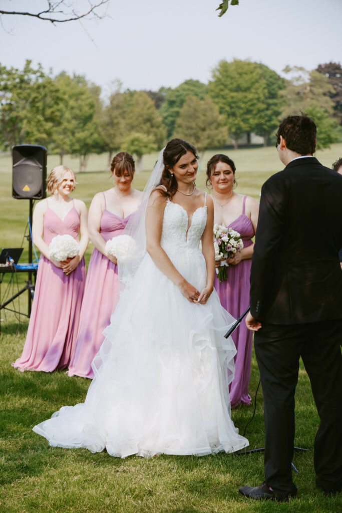 Bride stands at alter with bridesmaid behind her