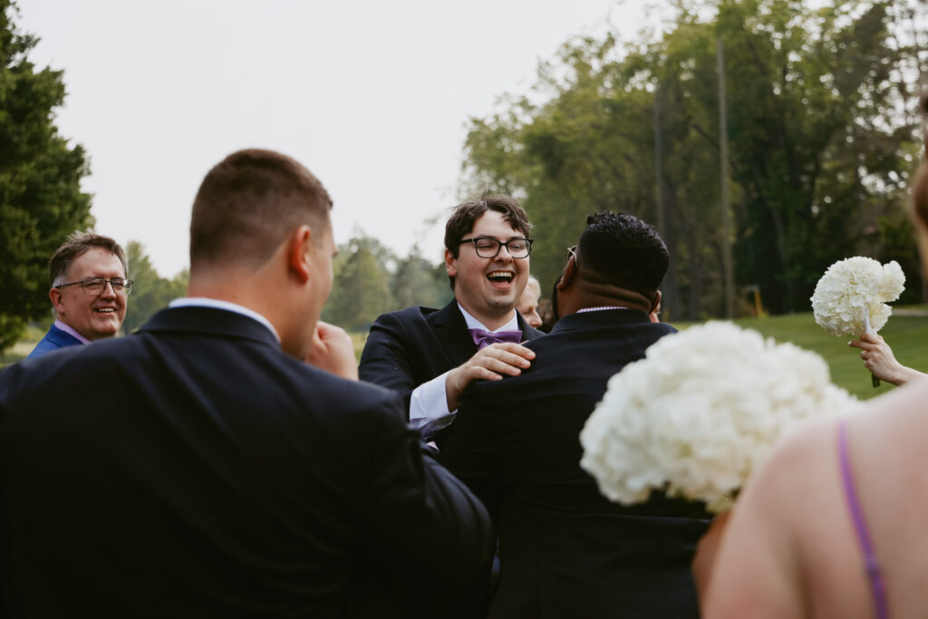 Groom hugs groomsman