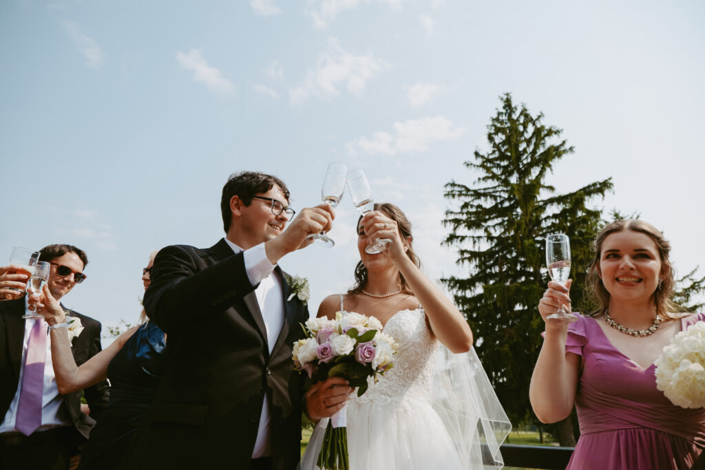 Bride and Groom clink glass during cocktail hour