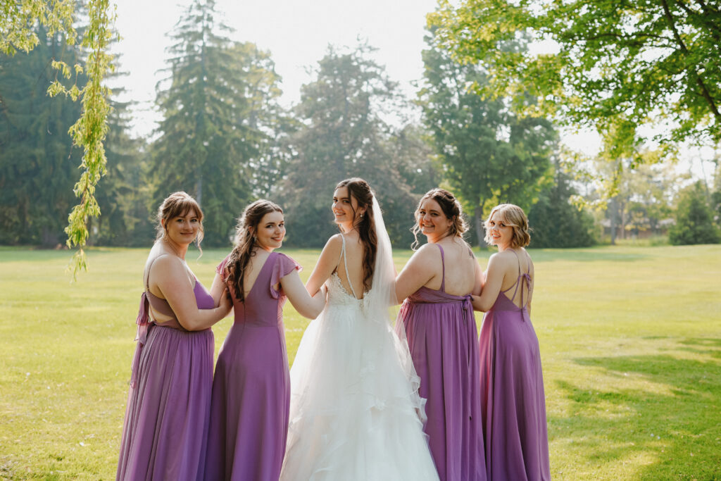 bride and bridesmaids looking back at camera over their shoulders