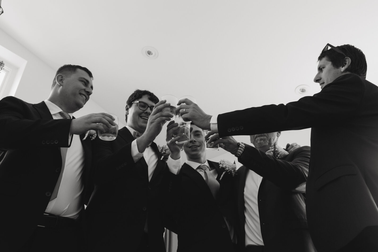 Grooms men clink their glasses