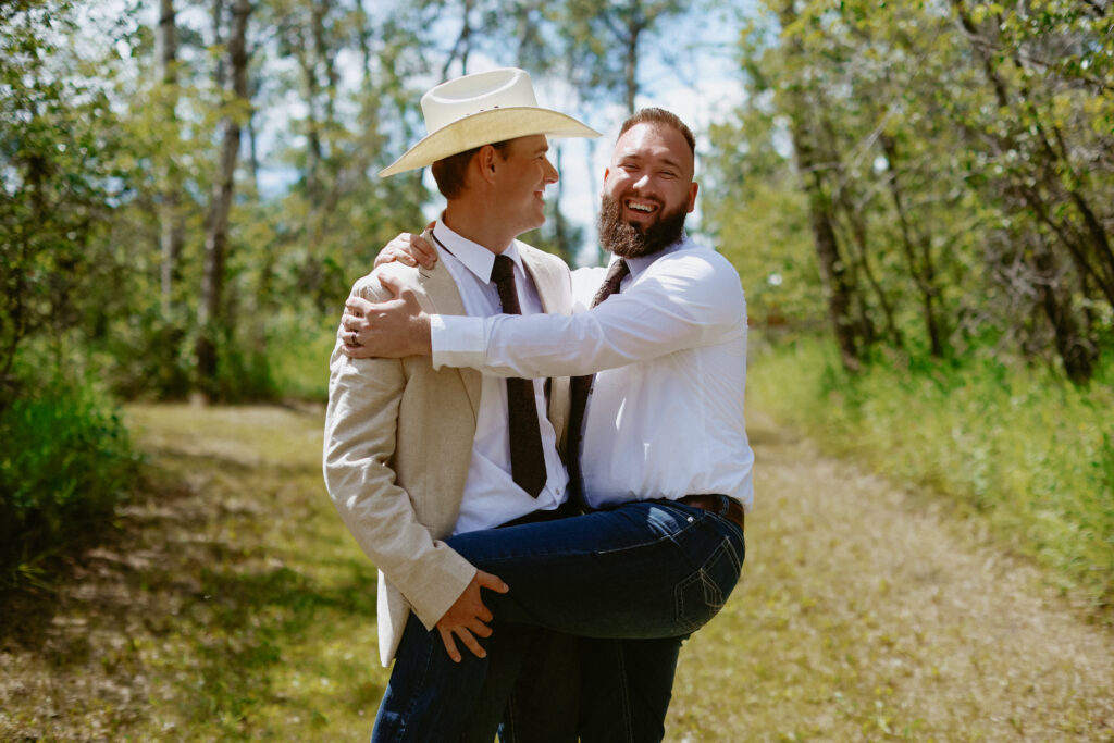Groom jokes with groomsmen by lifting leg of groomsmen.