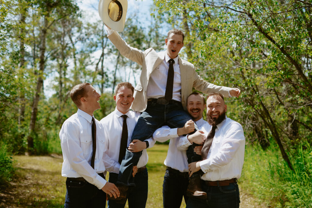 Groom get lifted by groomsmen