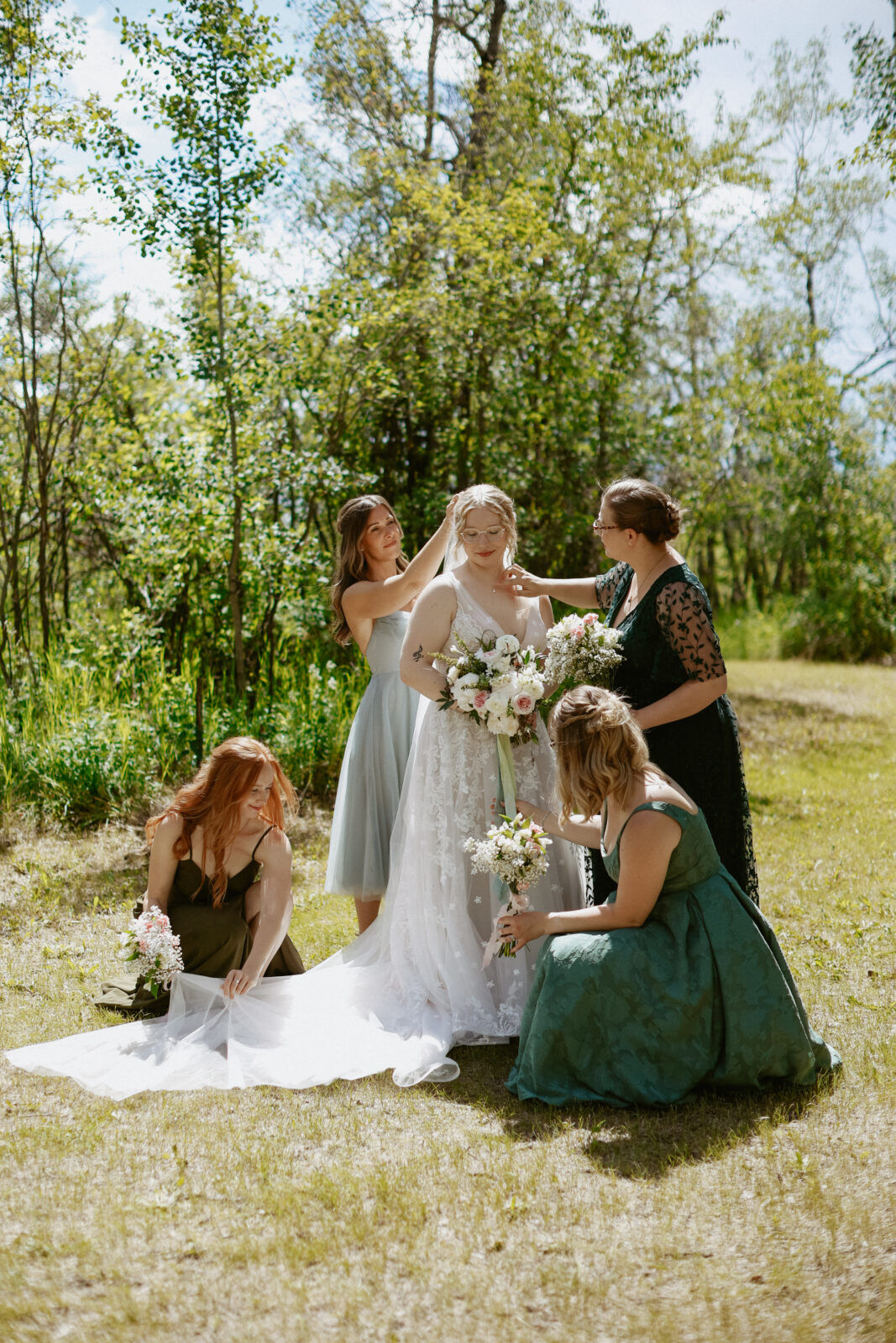 Bridesmaids help arrange the brides dress