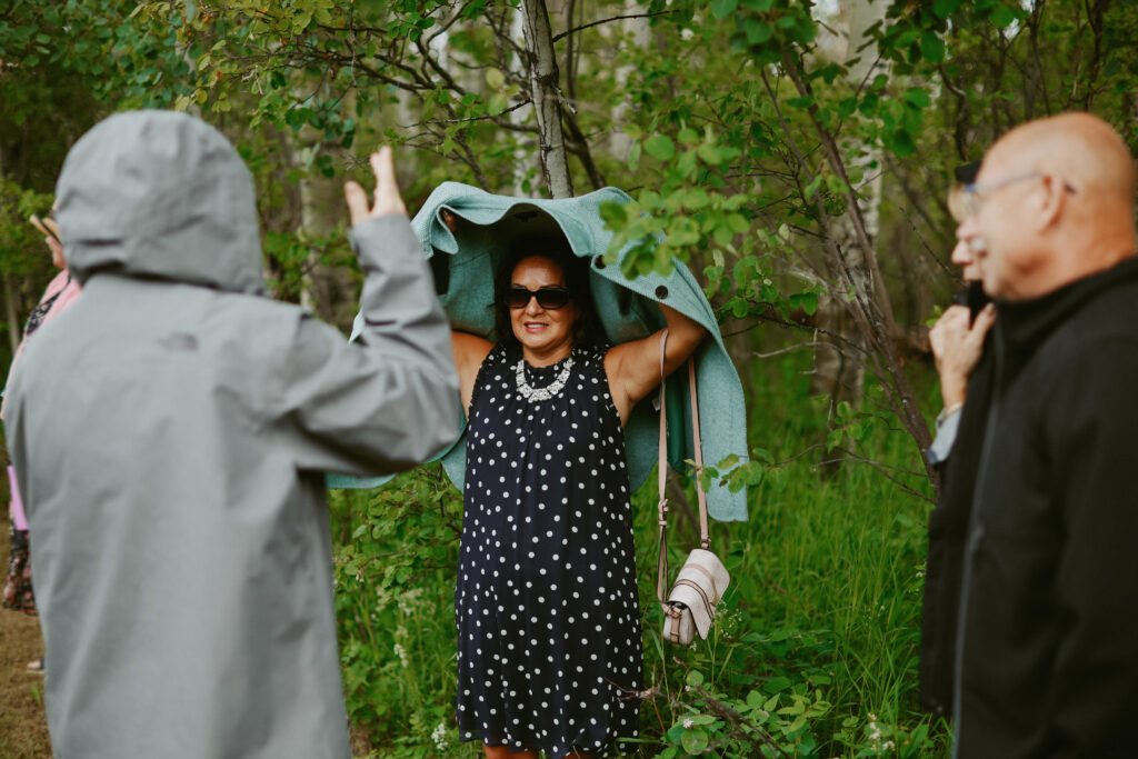 wedding guest hides under jackets from the rain