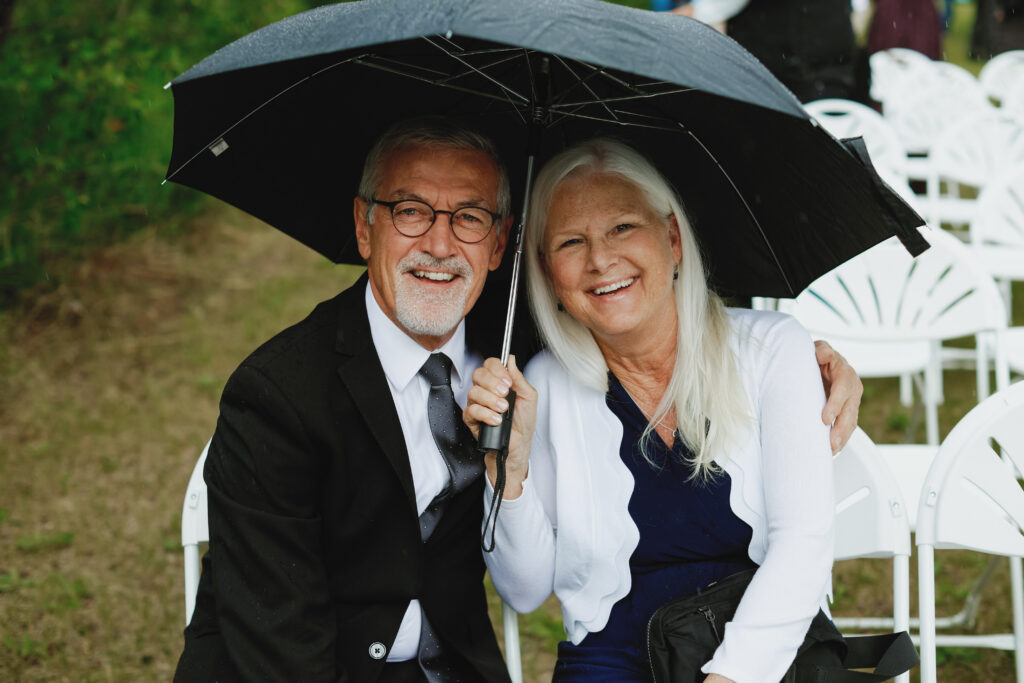 couple huddles under umbrella