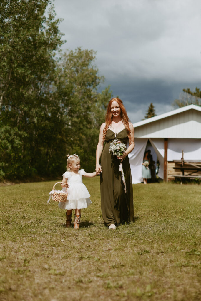Bridesmaid walks down aisle with flower girl 