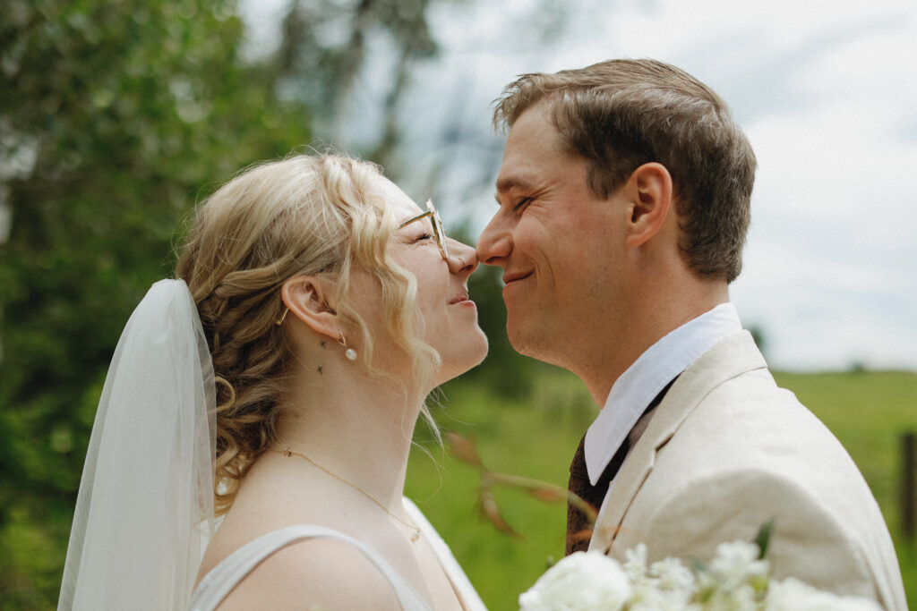 Bride and Groom face each other with nose touching. 
