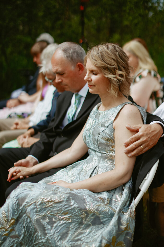 wedding guest holds hands while prayer is being read