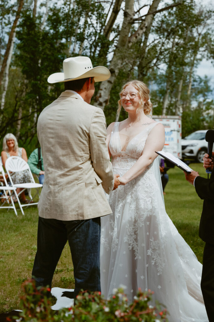 bride and groom holds hands at alter