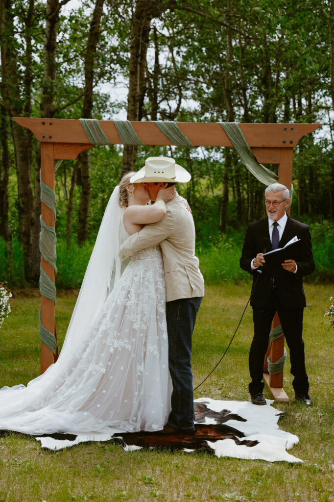 bride and groom kiss at alter
