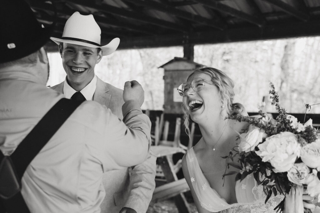 Bride and Groom laugh with guest