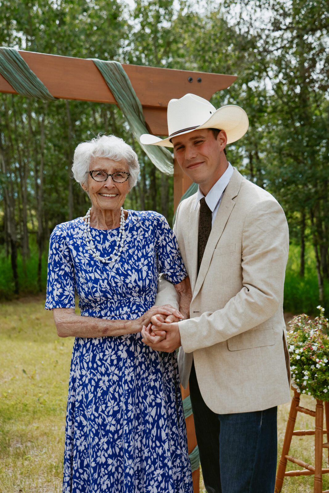 Groom stands with grandmother at alter