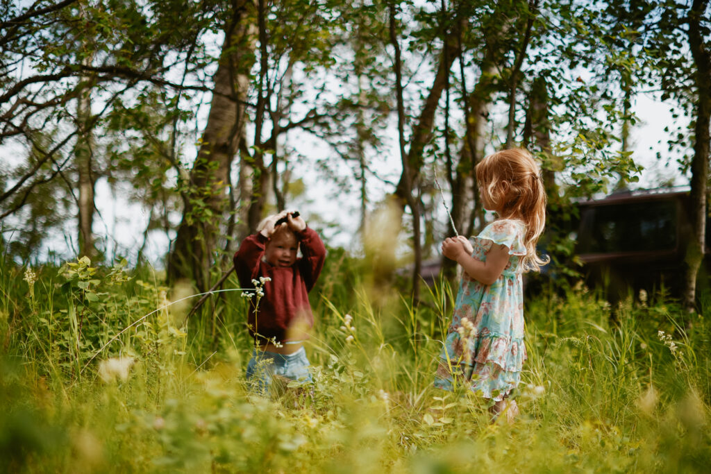 Kids play in long grass after ceremony.