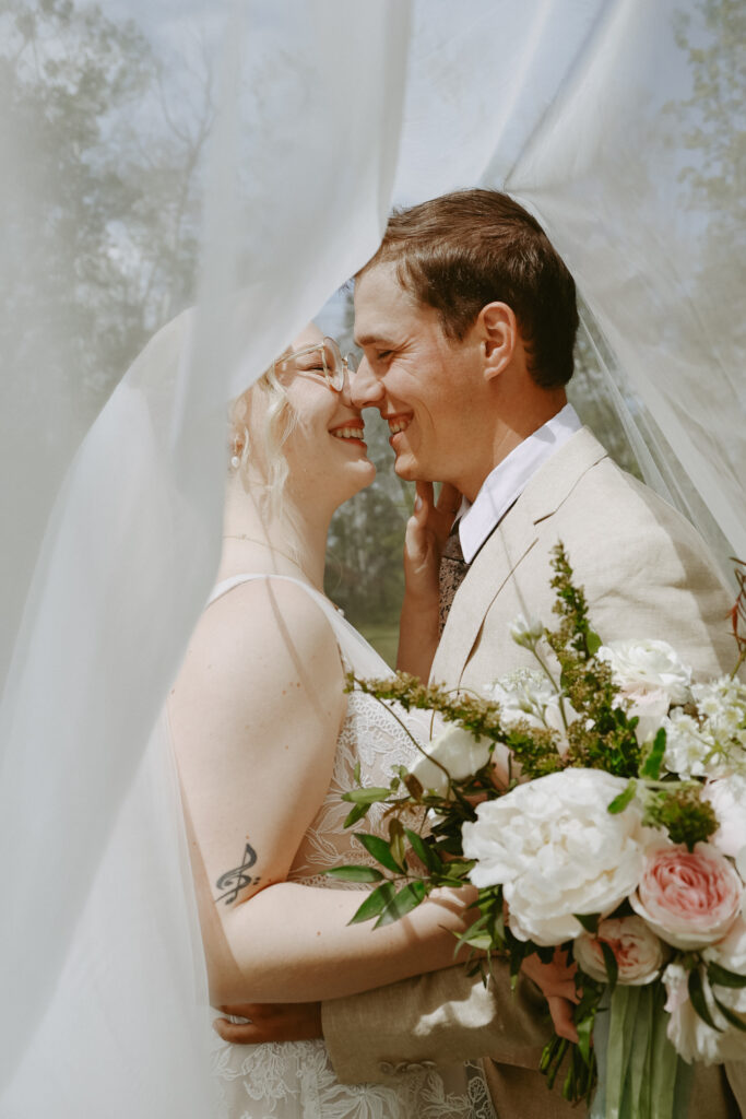 bride and groom kiss under veil