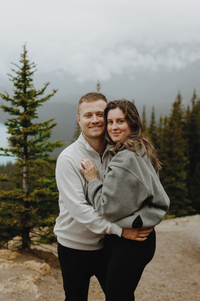 Couple hugs on top of a mountain
