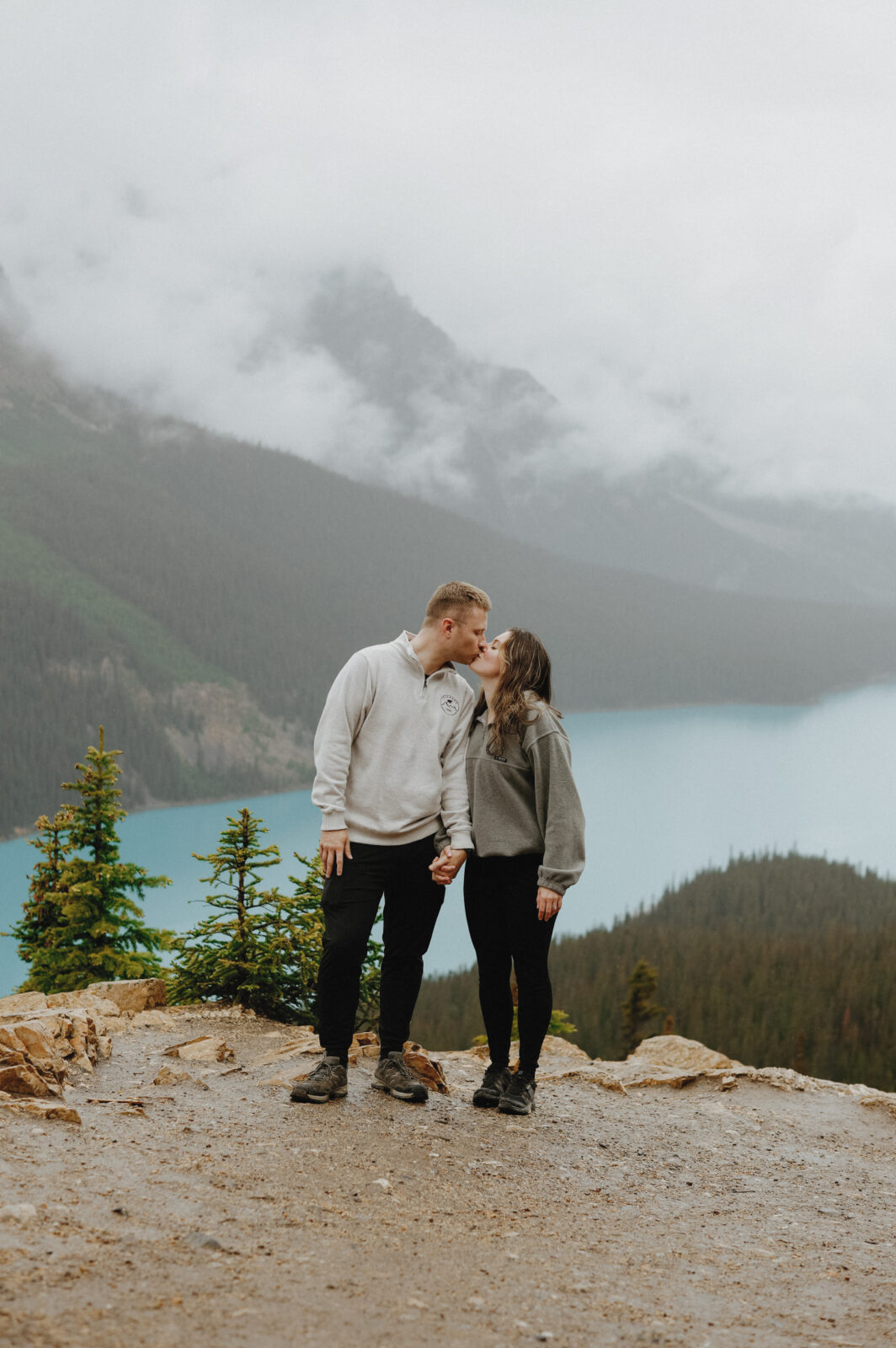 Couple kisses with Alberta mountains in the background