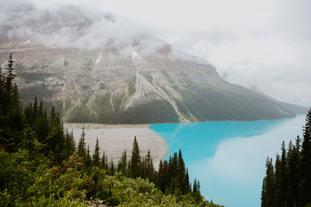 Landscape photo. Crystal blue lake with trees and mountain in the background. 